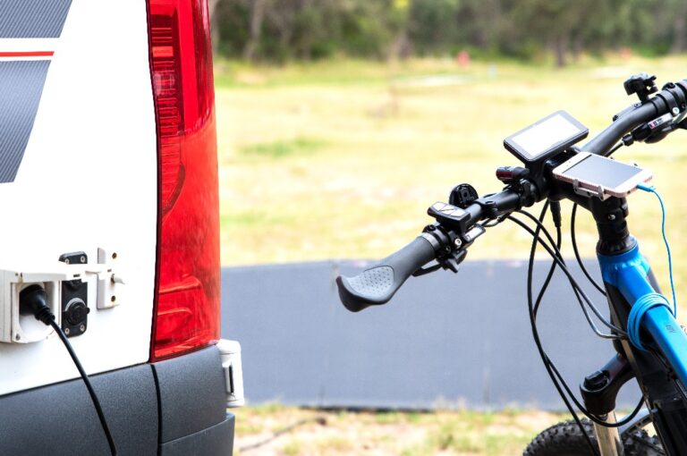 Elektrofahrrad, das für den täglichen Transport und das Training genutzt wird, wird von Solarzellen über den Wechselrichter des Wohnmobils geladen