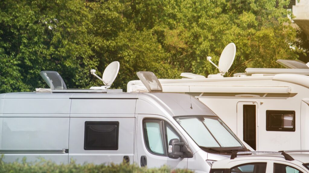 Satellitenschüsseln auf Wohnwagen. Elektronische Geräte in Transportern und Wohnmobilen zum Empfang von Videosignalen (Textfeld oben im Bild)